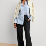 Stitch Fix model wearing women’s coastal grandmother outfit with black trousers, blue shirt, beige jacket, white sneakers.