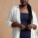 Stitch Fix model wearing women’s coastal grandmother outfit with navy sleeveless knit midi dress and white button-down top.