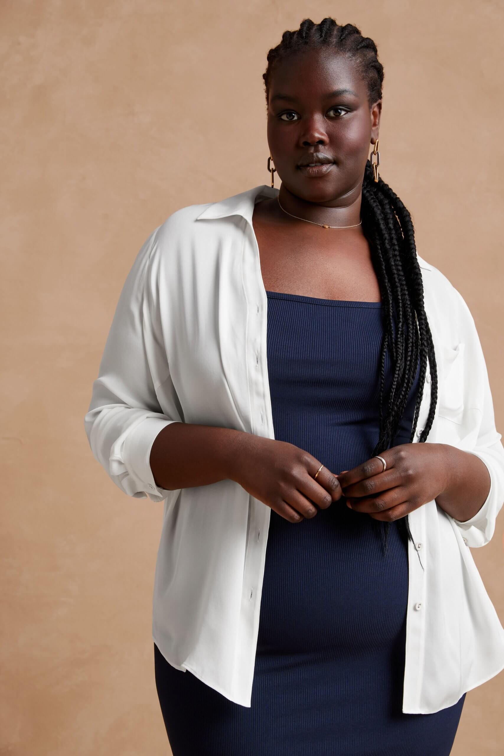 Stitch Fix model wearing women’s coastal grandmother outfit with navy sleeveless knit midi dress and white button-down top.