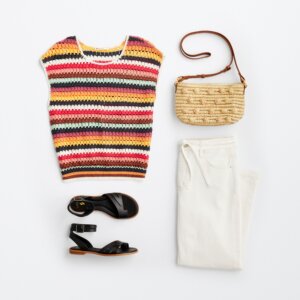 summer travel outfit with striped shirt, black sandals, and sun bag.