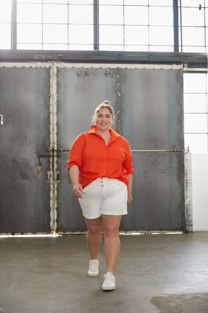 Outfit for baseball game with orange top, white shorts, and white sneakers