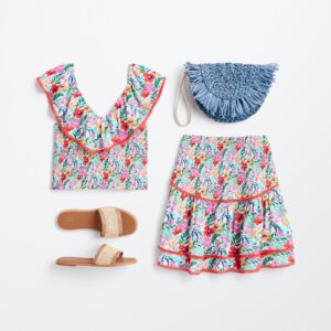 summer beach wedding outfit for women patterned skirt and top with straw clutch