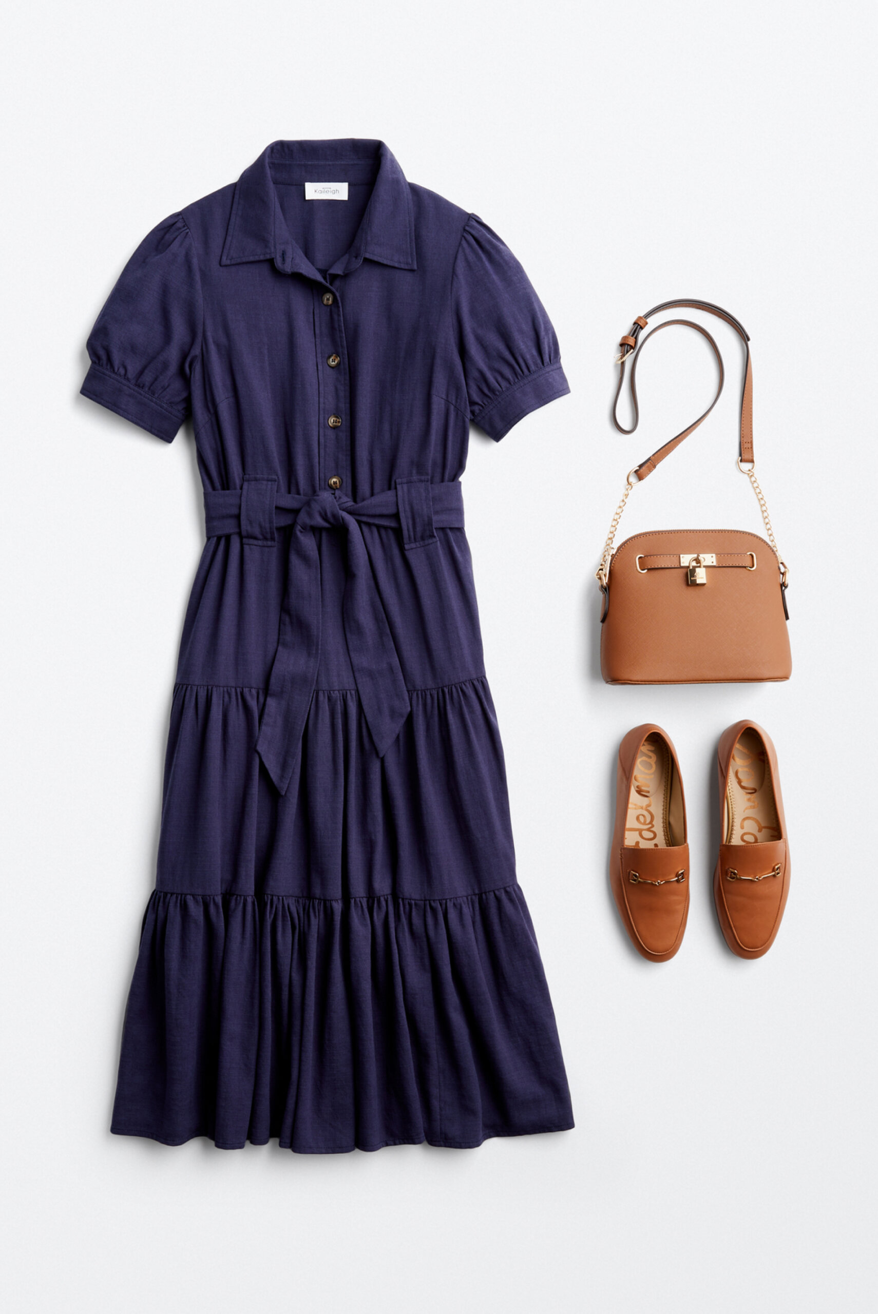 Alt text: A maxi blue polo dress with a cloth belt, a brown cross-body purse and brown flats arranged together for outfit inspiration. 